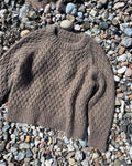 PetiteKnit brauner Jenny Sweater liegt am Strand