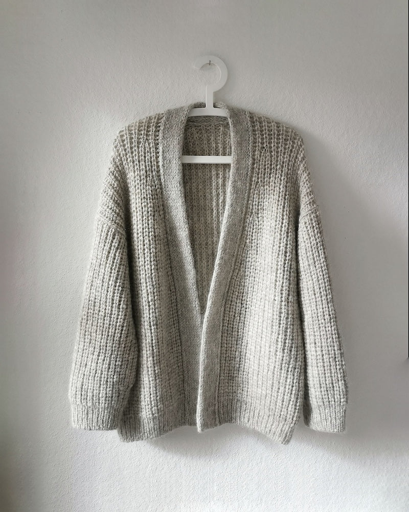 Clara Cardigan von Paula-m gestrickt mit Petite Wool auf einem Kleiderbügel