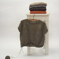 Raglan Basics Pullover von Regina Moessmer, angestrickter Pullover auf Kleiderbügel und fertige Stücke gefaltet auf Hocker